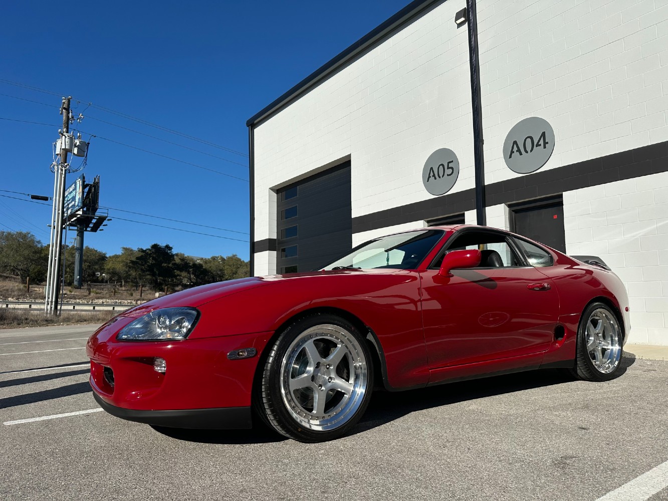 Toyota Supra Front Three-Quarter View After Detailing Red MK4 Toyota Supra after ceramic coating application parked outside detailing studio