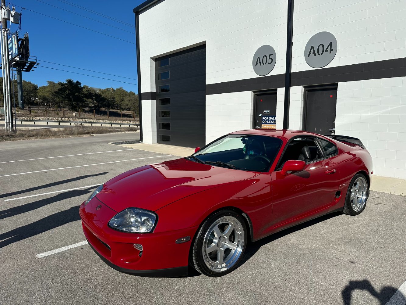 MK4 Supra Paint Correction Results in Natural Light Toyota Supra MK4 with polished aluminum wheels after professional detailing