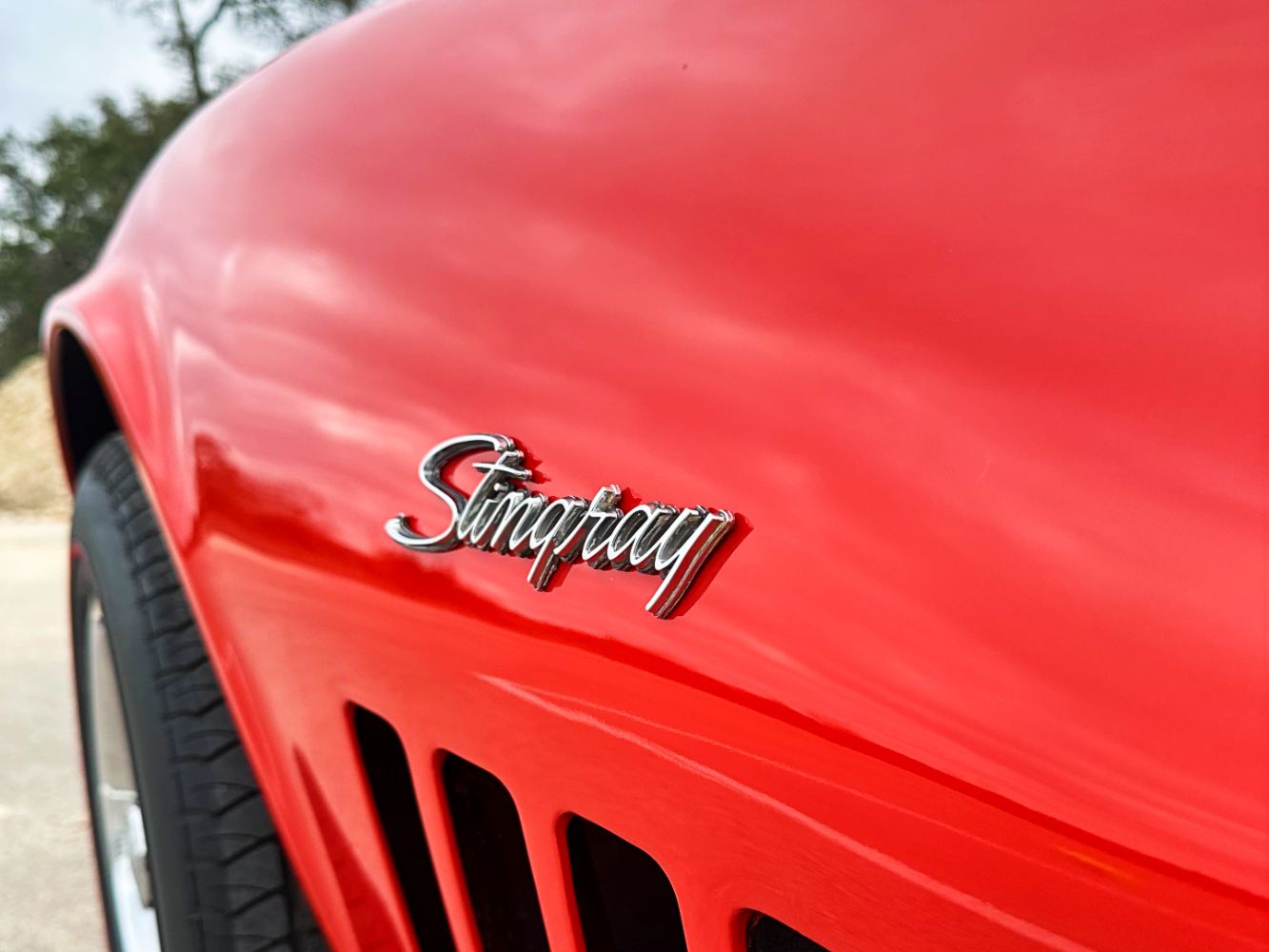 Stingray Emblem Detail After Paint Correction Close-up of Corvette Stingray emblem on Monza Red paint after detailing