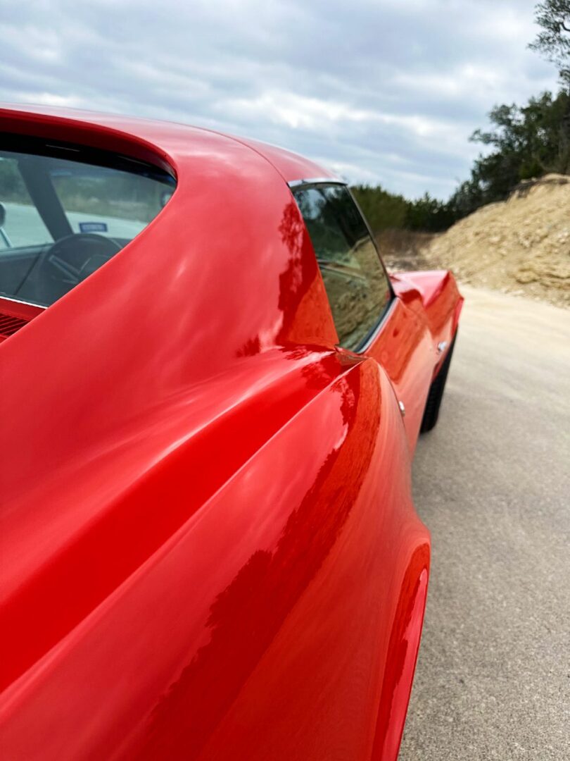 Close-up of Monza Red Corvette quarter panel after single-stage paint correction