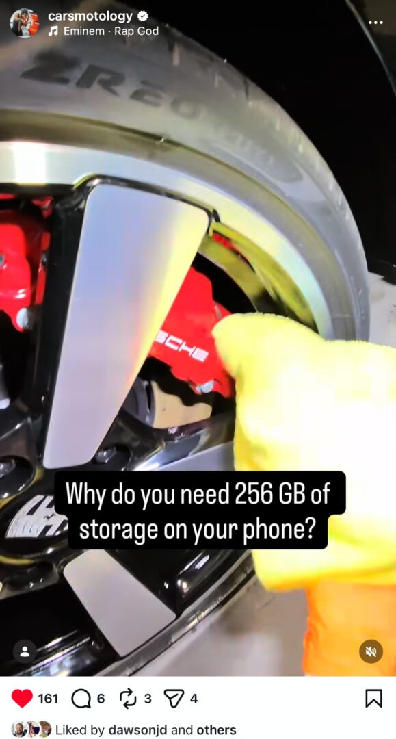 Detailer cleaning Porsche brake calipers and wheels during wheel detailing.