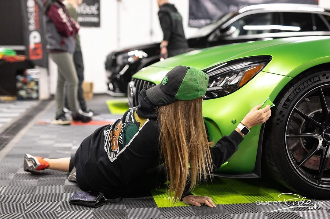 Detailer applying ceramic coating to green sports car at Carsmotology in Boerne Texas