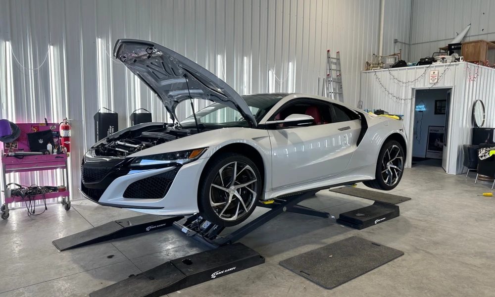 Acura NSX with the hood open on race ramps getting paint protection film prepped at Carsmotology in Boerne, TX