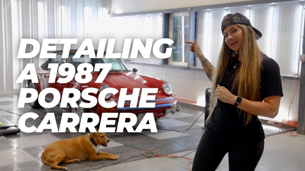 Jen of Carsmotology pointing to the title Detailing a 1987 Porsche Carrera, with a red Porsche 911 Carrera Cabriolet behind her in the Boerne, TX detailing shop