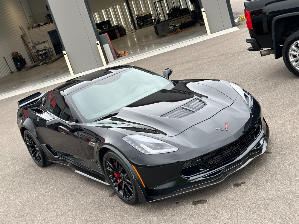 Black C7 Corvette front three-quarter view after full-body Stek paint protection film installation at Carsmotology