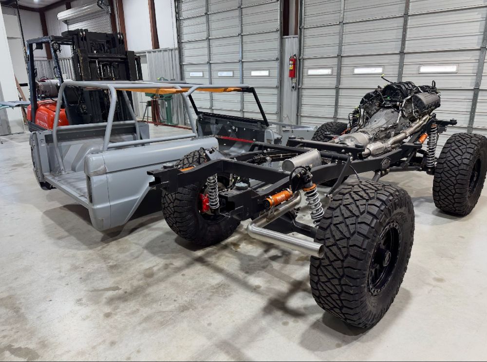 Body-off custom Bronco restoration showing the bare Kincer chassis with a 5.0 engine, six-speed transmission, and coilover suspension