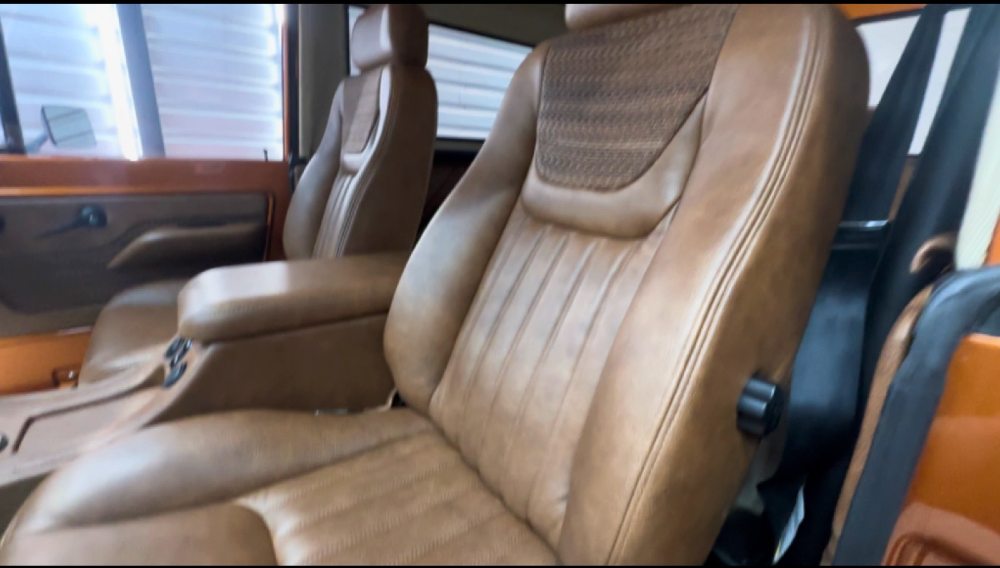 Custom tan leather bucket seats with diamond-quilted inserts inside the custom Ford Bronco by Nickel Aviation Interiors