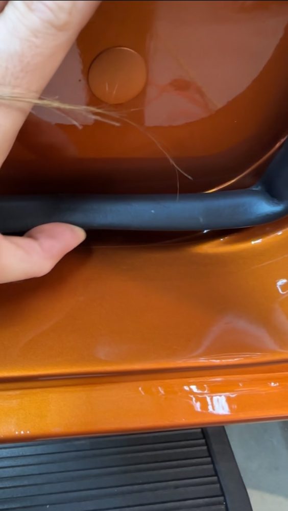 Custom-cut paint protection film wrapping the lower front fender edge of the burnt-orange custom Bronco