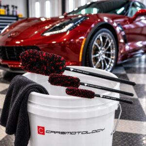 Wheel Woolies Brush 3 Piece Kit resting on a Carsmotology bucket beside a red Corvette