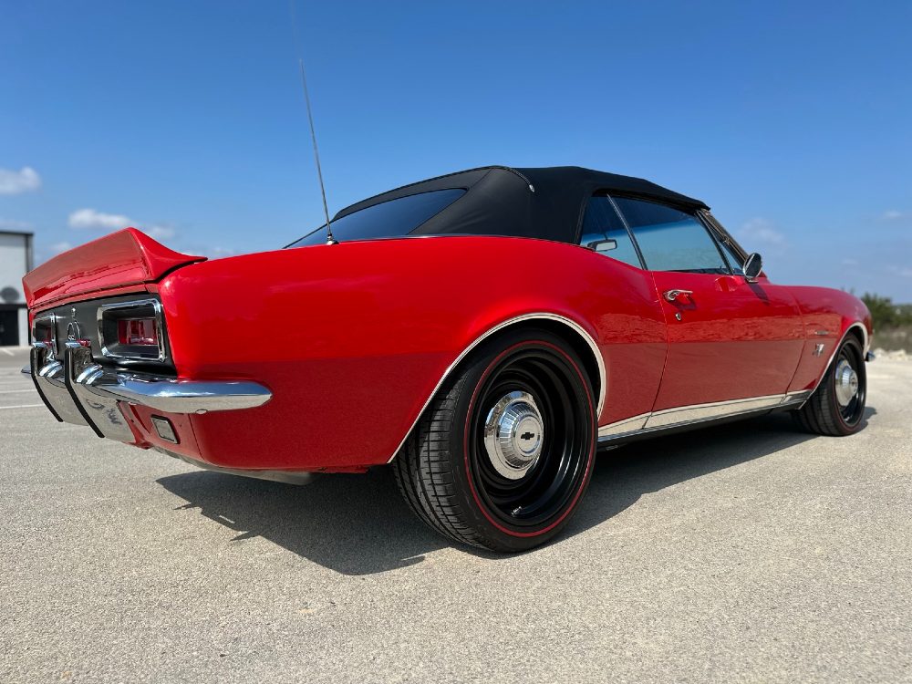 Rear three-quarter 1967 Chevrolet Camaro SS/RS convertible with glossy red ceramic coating by Carsmotology and matte black wheels