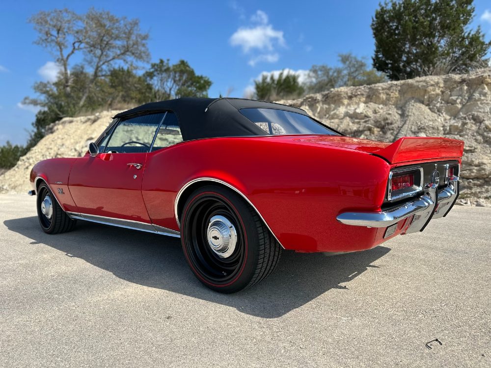 Driver-side rear 1967 Chevrolet Camaro SS/RS convertible detailed by Carsmotology with glossy red paint and redline tires