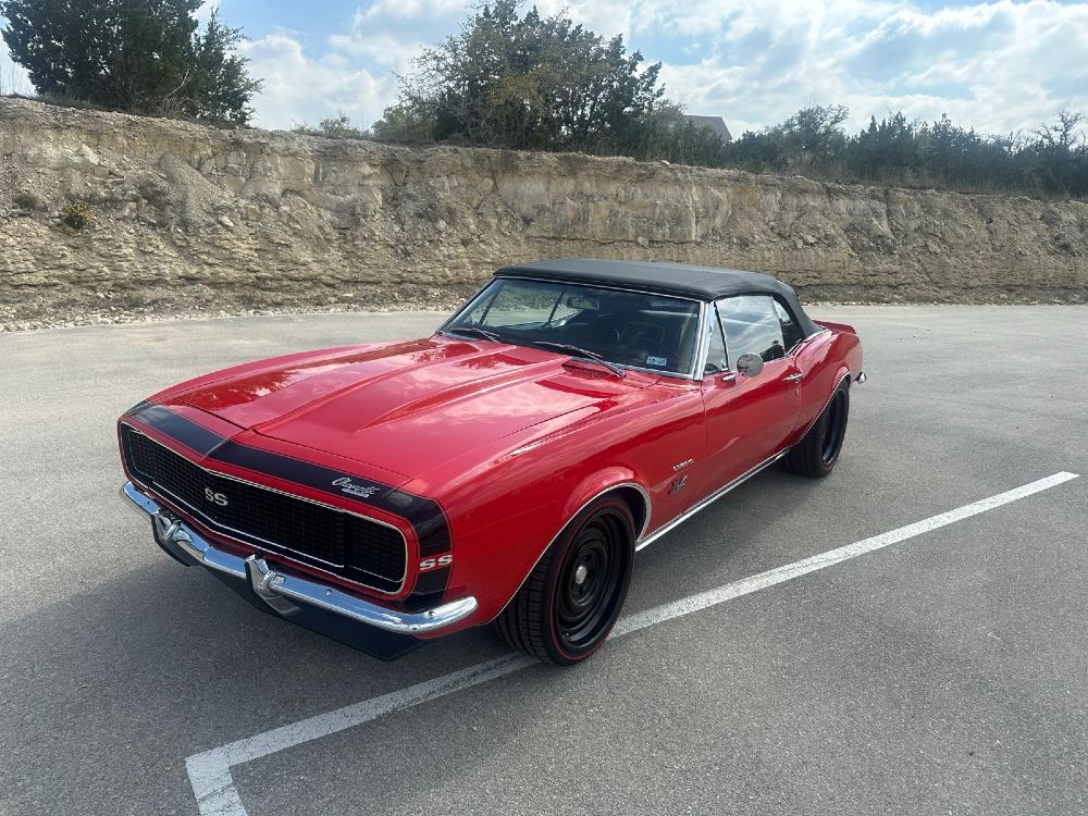 Front three-quarter 1967 Chevrolet Camaro SS/RS convertible detailed by Carsmotology with red paint and matte black wheels