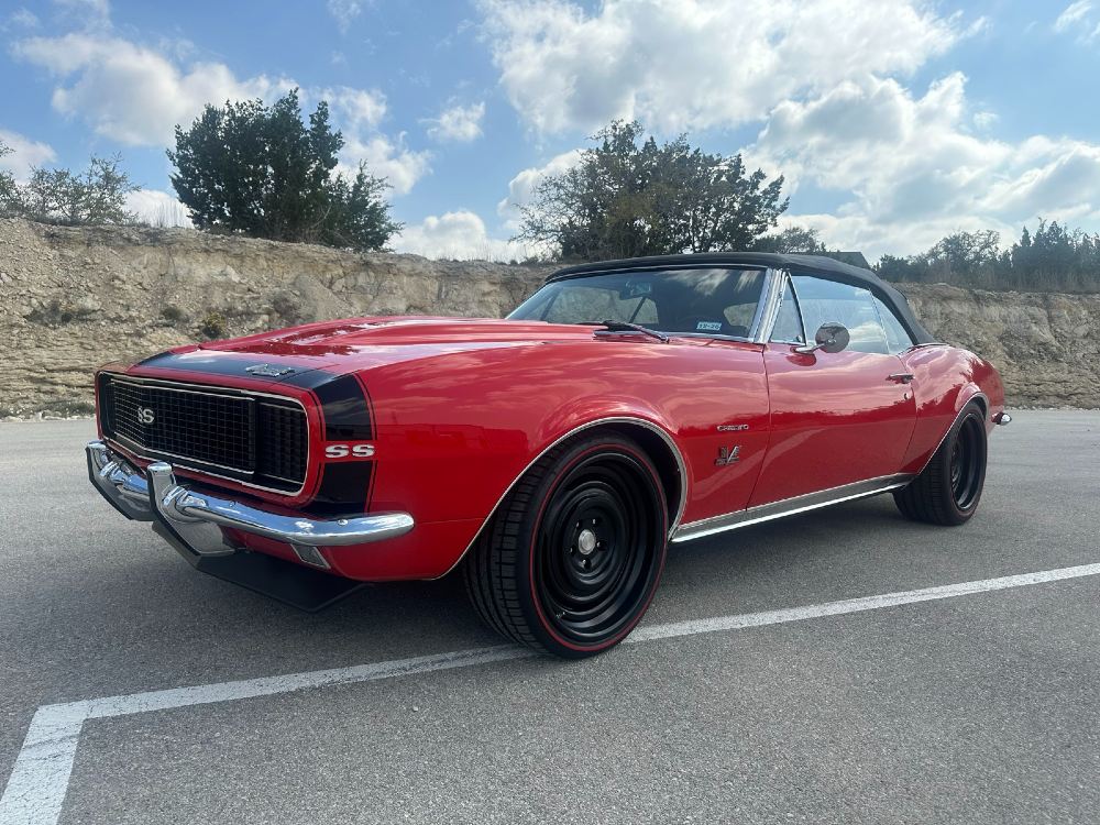 Front driver-side 1967 Chevrolet Camaro SS/RS convertible with matte black wheels and glossy Carsmotology red paint