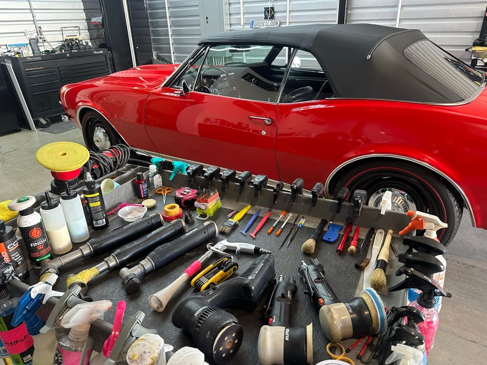 1967 Chevrolet Camaro SS in the Carsmotology detailing bay surrounded by Rupes polishers, pads, and compounds for paint correction