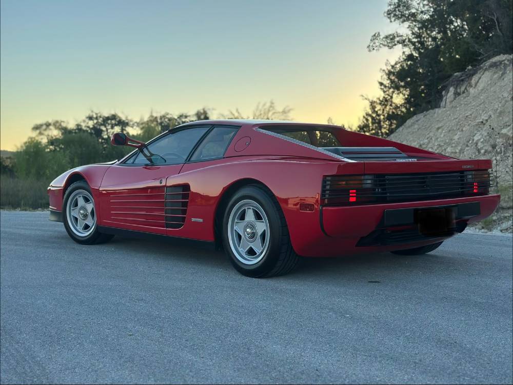 Full side profile of a red 1986 Ferrari Testarossa with glossy ceramic-coated paint after detailing by Carsmotology
