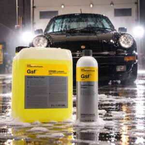 Koch Chemie Gentle Snow Foam 1 liter bottle and 5 liter container in front of a foamed-up black Porsche 911